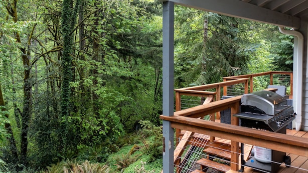 A wooden deck with a barbecue grill, surrounded by dense forest. - Entire 4-bedroom house, billiards and ping-pong, close to University of Oregon (Eugene)