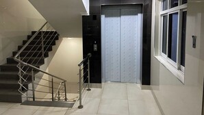 A modern interior with a staircase, a door with a number plate, and a window. - Neema Executive Suites Near Junction Mall 5A (Nairobi)