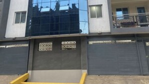 A multi-story building with a reflective glass facade, balconies, and a gated entrance. - Neema Executive Suites Near Junction Mall 5A (Nairobi)