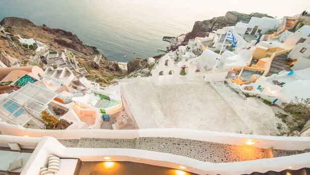 A coastal hotel with white buildings, a pool area, and a view of the sea. - Sophia Privilege (Santorini)