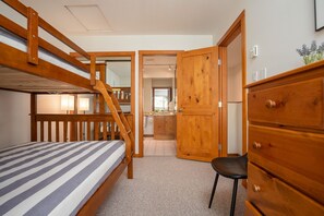 A bunk bed room with a wooden door, a desk, and a chair. - 2BR | Symphony | Dog Friendly | Hot Tub | Private Balconies | Village Location | Parking (Whistler)
