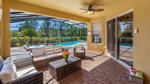 Eine Außenpatio mit Pool, Sitzbereich und Deckenventilator.