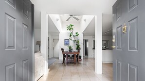 A modern interior with a dining area, grey doors, and a ceiling fan. - Family vacation home at Cultus Lake - Pet Friendly (Cultus Lake)