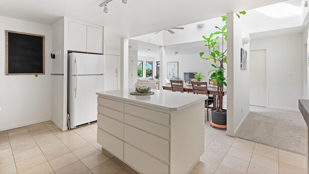 A modern kitchen with a central island, white cabinetry, and a built-in refrigerator. - Family vacation home at Cultus Lake - Pet Friendly (Cultus Lake)