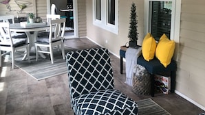 A cozy living room with a patterned sofa, a wooden coffee table with candles, and a dining area with a table and chairs. - Sparkling Home in Saugatuck area! (Douglas)