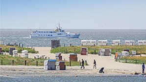 En strand med en båt, strandhytter och ett sandområde.