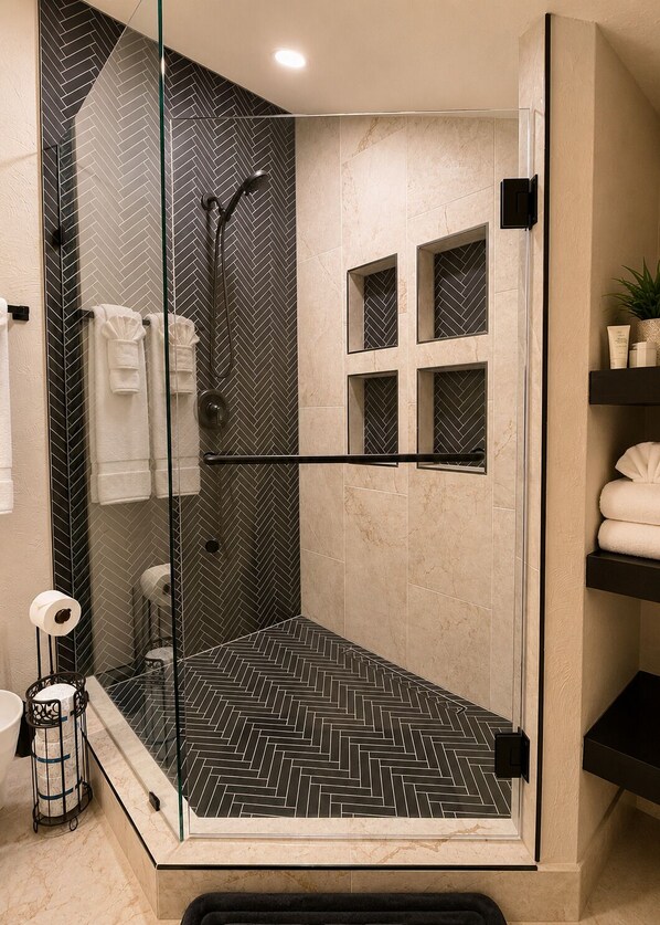 A modern bathroom with a glass-enclosed shower, a herringbone-patterned floor, and a marble wall. - Downtown Mountain View Condo- 2 Blocks to Main St (Breckenridge)