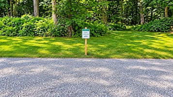 A sign indicating a guest parking area with a gravel path leading to it.