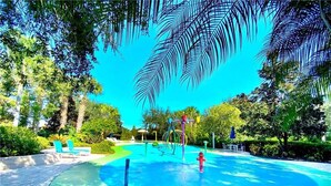 A water play area with a circular pool, surrounded by lounge chairs and umbrellas. - Amazing Bahama Bay Resort, close to Disney (Davenport)