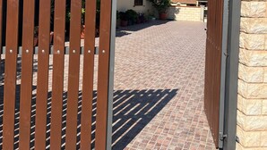Une entrée fermée par un portail mène à un immeuble sur lequel est apposée une enseigne indiquant « Casa Vacanze Sandalia ».