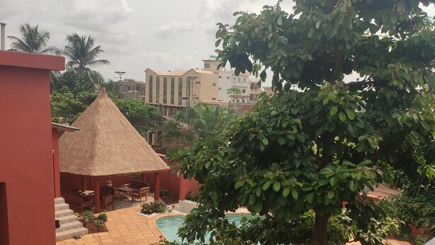 A courtyard with a pool, surrounded by greenery and buildings. - Lagoon Residence Appt Bioguera (Porto-Novo)