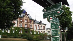 Un panneau indicateur directionnel avec de nombreuses flèches pointant vers différentes destinations et indiquant les distances.