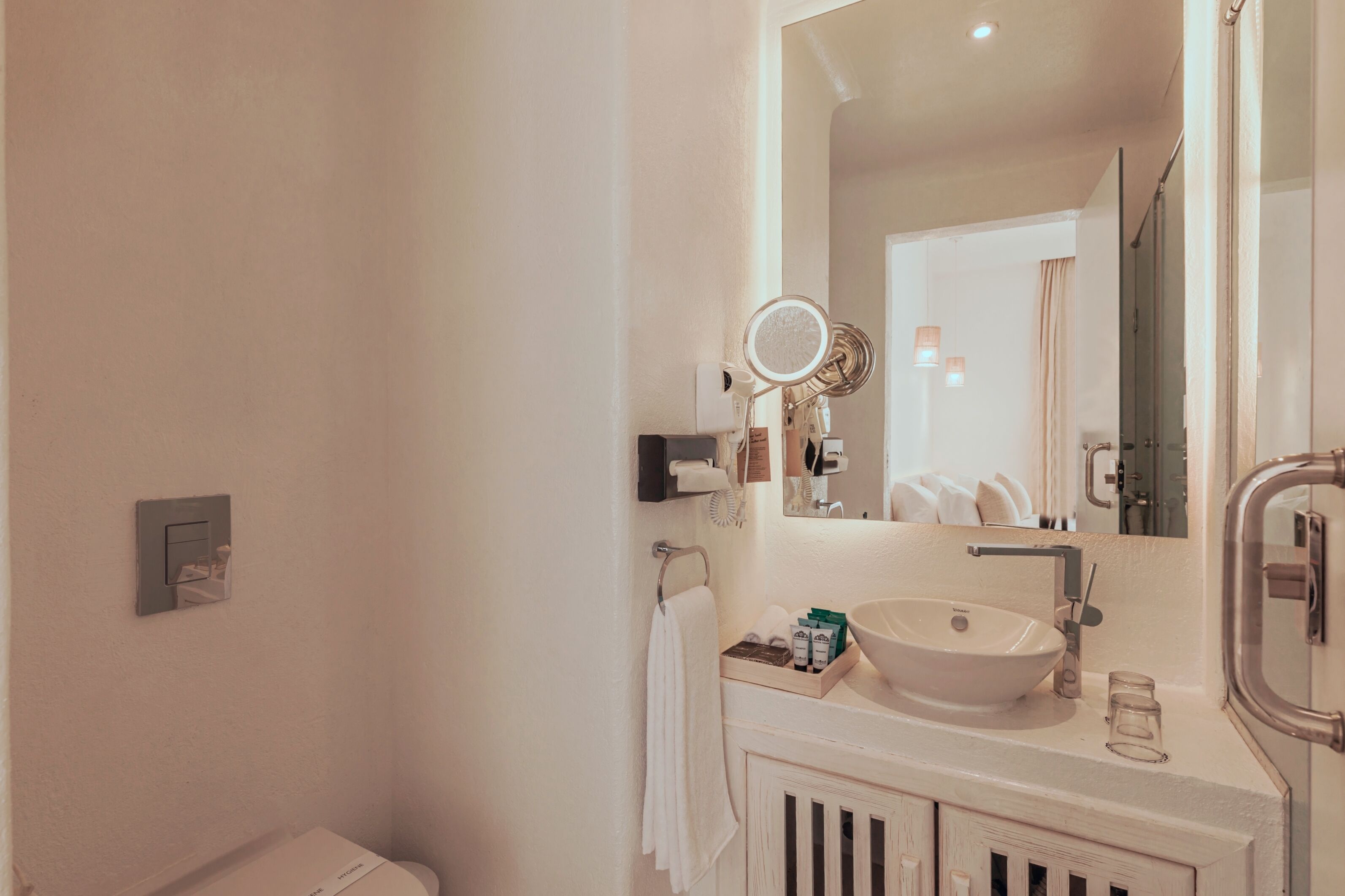 A bathroom with a white sink, mirror, and towel rack.
