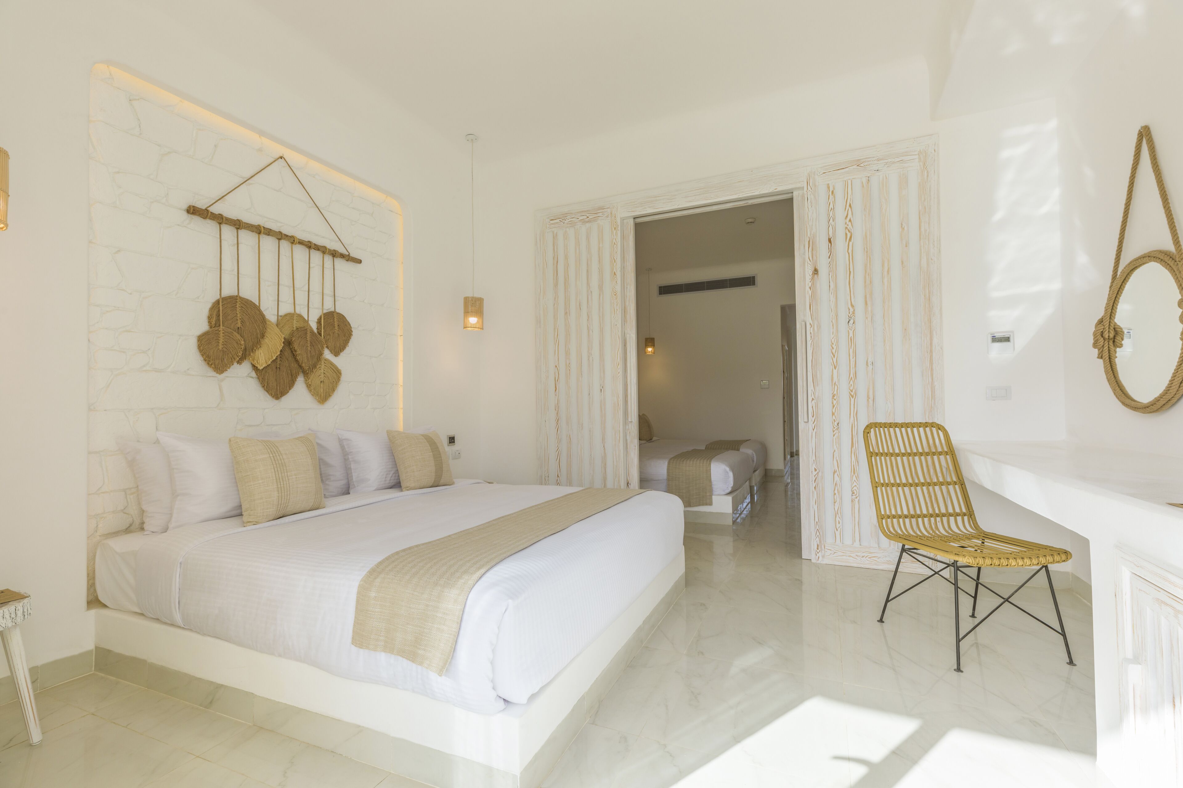 A spacious bedroom with a large bed, a chair, and a mirror.