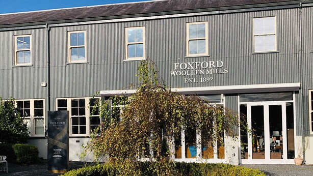 Un edificio a due piani con un cartello che riporta la scritta “Foxford Woollen Mills Fondata nel 1892”.