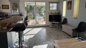 Un amplio salón con una televisión grande, una mesa de comedor y un sofá.