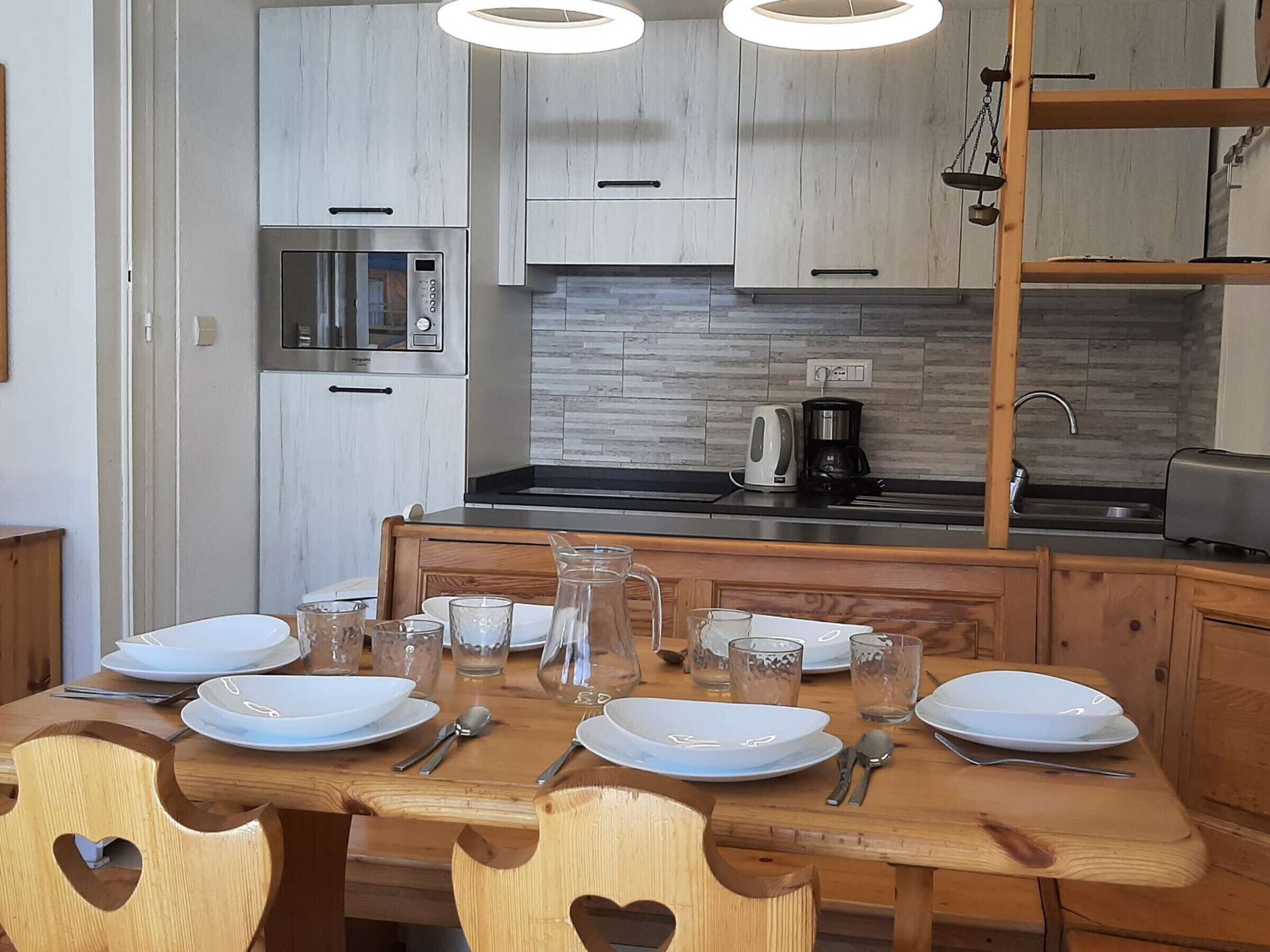 A modern kitchen with wooden cabinets, a built-in microwave, and a coffee maker on the counter.