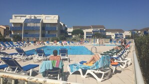 A poolside area with lounge chairs and a swimming pool. - Appart: T3 Front DE MER -orienté SUD - Terrasse 22 M2-2 Piscines- Parking (lacanau océan)