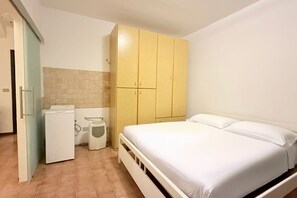 A bedroom with a bed, a wardrobe, a washing machine, and a radiator. - N232 - Numana, five-room apartment with garden in a residence with swimming pool (Numana)