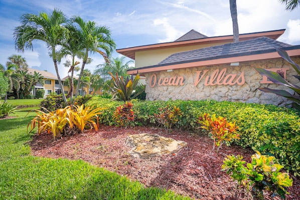 A landscaped area with a stone wall and the text "Ocean Villas" in the center.