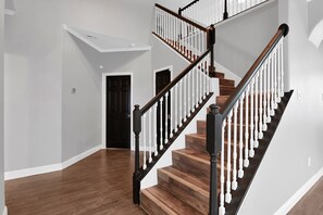A staircase with wooden steps and white balusters, leading to an upper floor.