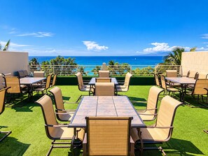 An outdoor seating area with tables and chairs, overlooking a body of water.