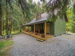 A rustic cabin with a stone chimney, wooden deck, and a covered porch. - Sunset Lake Cabin in Ripley, NY (Ripley)