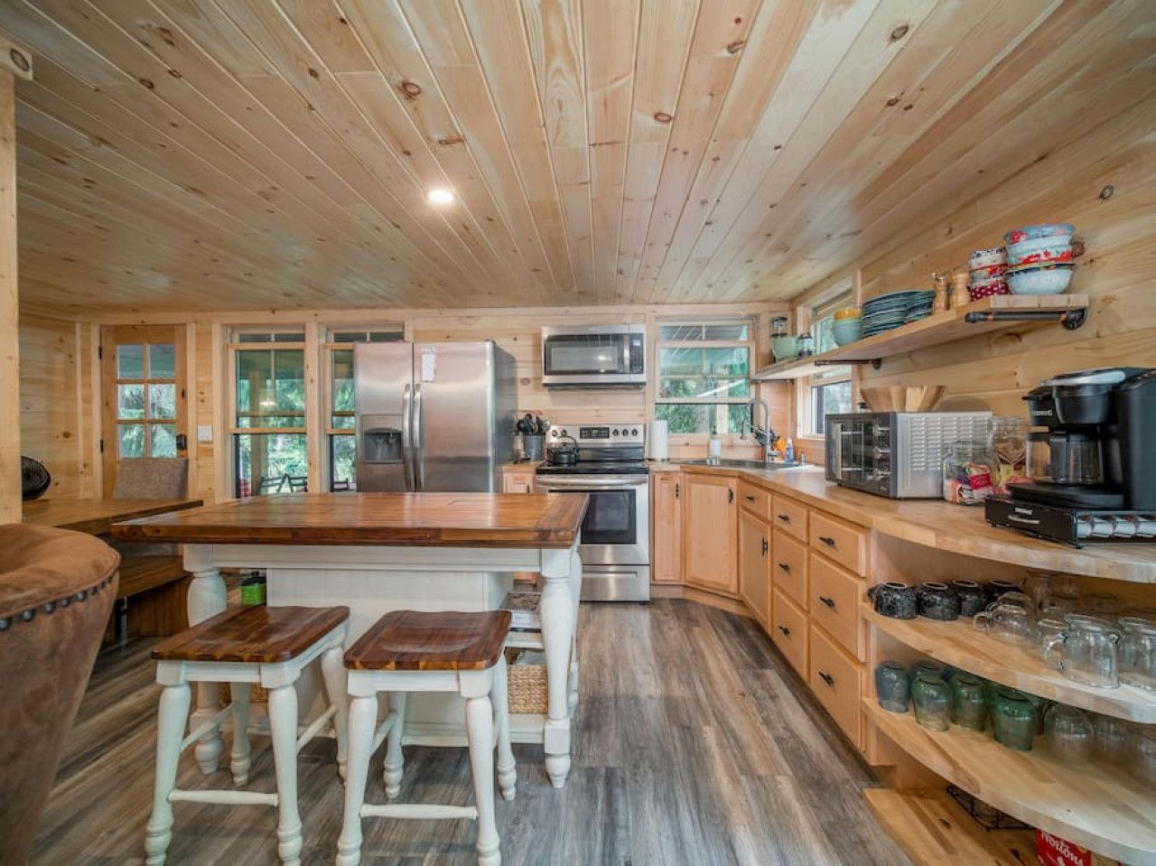 A wooden cabin kitchen with a central island, wooden cabinets, and a built-in microwave.