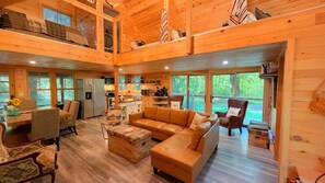 A spacious cabin interior with a living area, kitchen, and dining space.