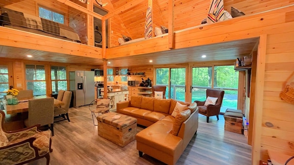 A spacious cabin interior with a living area, kitchen, and dining space.