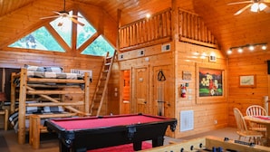 A wooden cabin with a pool table, a foosball table, bunk beds, and a loft area with a ladder. - MTN views! PoolTable, AirHockey, Foosball, HotTub, FirePit; Perfect for FAMILIES (Sevierville)