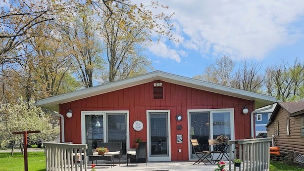 A red cabin with a porch, steps, and potted plants. - Bemus Point Lake Front Cottage with Dock (Bemus Point)