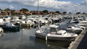 A marina with numerous boats docked in calm waters, surrounded by buildings and trees. - Family house with arge garden - peaceful & close to Arcachon Bay - sleeps 6 (Gujan-Mestras)