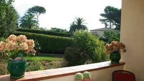 A balcony with potted plants, a table, and a chair. - Residence Michel Ange Cagnes sur Mer 2BR, 2 baths (Cagnes-sur-Mer)