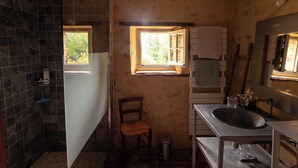A rustic bathroom with a shower, a sink, and a window. - La Ferme du Pré Martin guest room (La Genevraie)