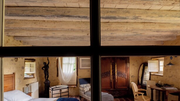 A room with a bed, a chair, a table, and a mirror. - La Ferme du Pré Martin guest room (La Genevraie)