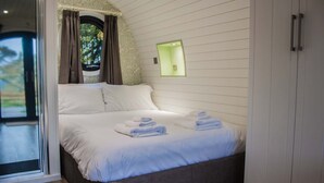 A bedroom with a bed, a window with curtains, a night light, and a wardrobe. - Foxtail Glamping Pod - sleeps 2 | Gold Award winning (Pickering)