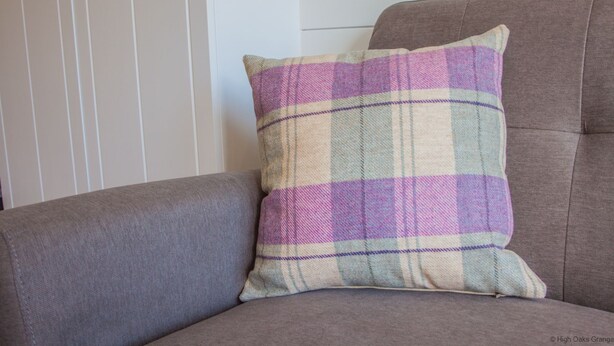 Un fauteuil gris avec un coussin à carreaux.