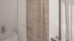 A modern shower with a glass enclosure, a handheld showerhead, and a wall-mounted control panel.