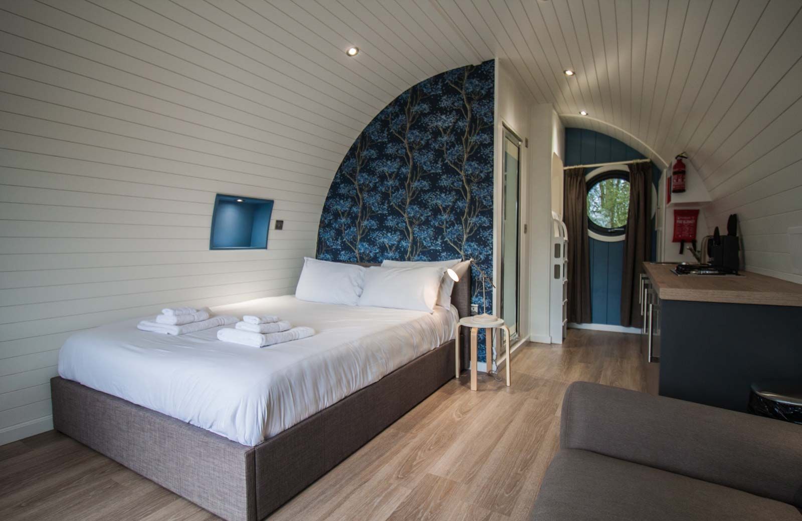 Una camera da letto con un letto grande, un tavolino e vista sulla cucina.