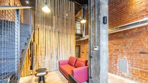 A modern interior with a red sofa, a staircase, and exposed brick walls. - Art Loft 04 'On Stage' in Valencia (València)