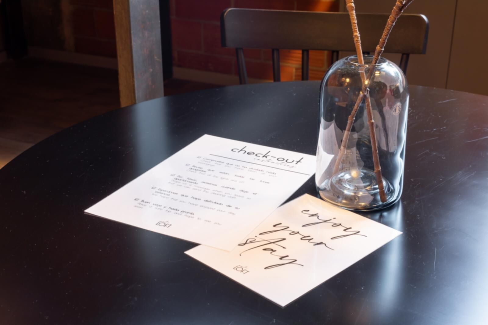 Une table avec un menu, un vase en verre contenant une baguette magique et une carte avec un message écrit à la main.