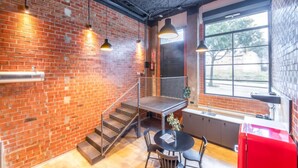 A modern kitchen with brick walls, a staircase, a window with a view, and a red appliance. - Art Loft 04 'On Stage' in Valencia (València)
