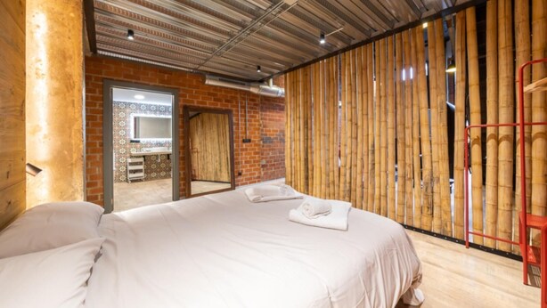 A hotel room with a large bed, a wooden wall, and a mirror. - Art Loft 04 'On Stage' in Valencia (València)