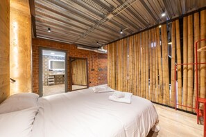 Une chambre d’hôtel avec un grand lit, un mur en bois et un miroir.