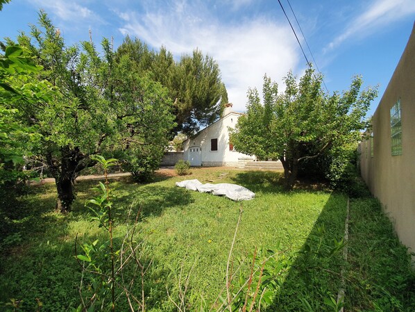 A small white building with a garden in front, surrounded by trees and greenery. - Maison Familiale DE Vacances (Châteaurenard)