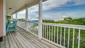 A wooden deck with a white railing, overlooking a beach and buildings. - Fully Renovated! Gulf AND Bay views! Inground Heated Pool! 2 min walk to beach! (Port St. Joe)