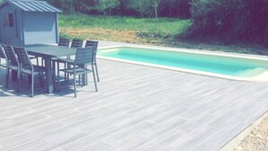 A wooden deck with a pool, a small shed, and outdoor furniture. - Chalet Bois Piscine Individuelle Dordogne (Saint-Hilaire-d'Estissac)