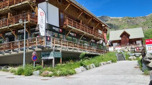 A wooden building with multiple balconies and signs for 'SKISET' and 'Bar Restaurant Le Grand Mont'. - 4/6-person apartment in Saint-Sorlin-d'Arves at the foot of the slopes (Saint-Sorlin-d'Arves)