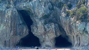 Entrada a una cueva costera con una playa al frente.